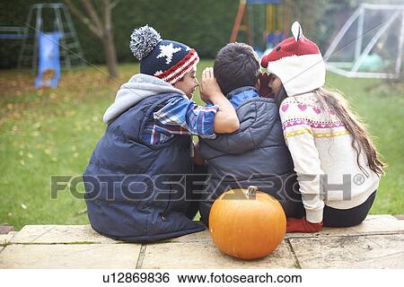 Stock Photograph - Siblings sitting on steps in garden. Fotosearch