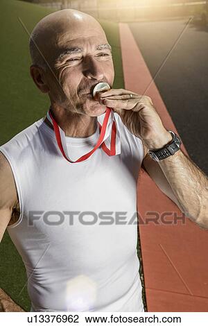 Sportsman kissing medal View Large Photo Image Stock Image - Sportsman kissing medal. Fotosearch