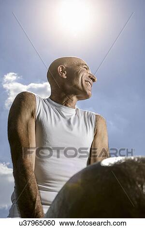Stock Image - Sportsman resting on pommel horse. Fotosearch