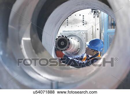 Stock Photo -  Steelworker measuring cast steel in engineering factory. Fotosearch