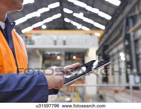 "Steelworker using digital tablet in engineering factory, close up" View Large Photo Image Stock Photograph - "Steelworker using digital tablet in engineering factory, close up". Fotosearch