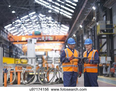 Steelworkers in discussion in engineering factory View Large Photo Image Stock Photograph - Steelworkers in discussion in engineering factory. Fotosearch