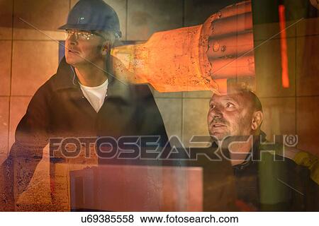 Stock Photo - Steelworkers in forging press control room. Fotosearch