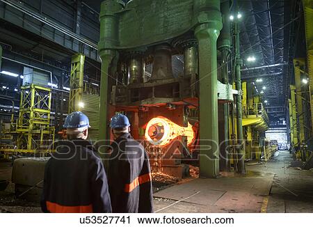 Stock Image - "Steelworkers with 10, 000 tonne forging press in steelworks". Fotosearch