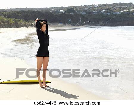 Stock Photograph - "Surfer stretching on beach, Roadknight, Victoria, Australia". Fotosearch