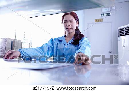 Stock Image - Technician working in LED factory. Fotosearch