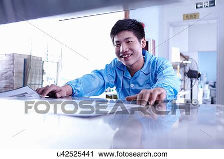 Stock Image - Technician working in LED factory. Fotosearch
