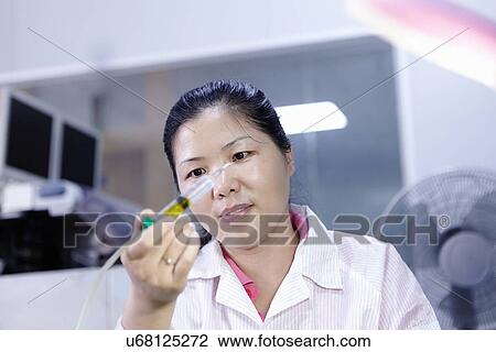 Stock Image - Technician working in LED factory. Fotosearch