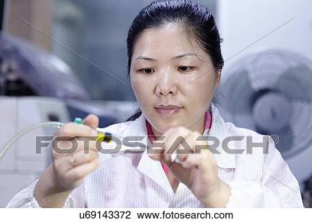 Stock Image - Technician working in LED factory. Fotosearch