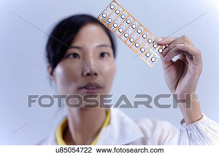 Stock Image - Technician working in LED factory. Fotosearch