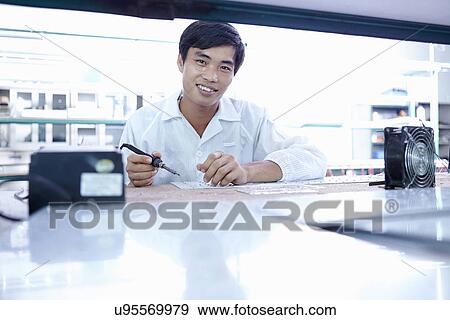 Stock Photo - Technician working in LED factory. Fotosearch