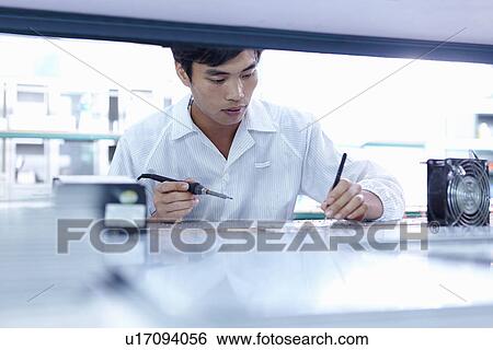 Technician working in LED factory View Large Photo Image Stock Photograph - Technician working in LED factory. Fotosearch
