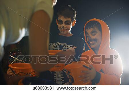 Three children wearing halloween costumes trick or treating View Large Photo Image Stock Image - Three children wearing halloween costumes trick or treating. Fotosearch