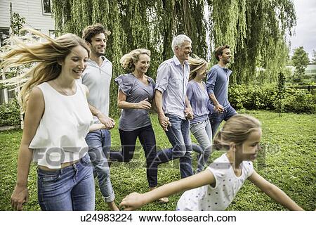 Picture - Three generational family running in garden. Fotosearch