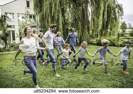 Three generational family running in garden View Large Photo Image Picture - Three generational family running in garden. Fotosearch