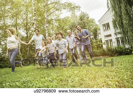 Three generational family running in garden View Large Photo Image Stock Photo - Three generational family running in garden. Fotosearch