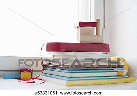 Stock Image - Toy boat on top of books on nursery window ledge. Fotosearch