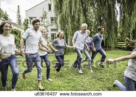 Stock Photo - Two generational family running in garden. Fotosearch