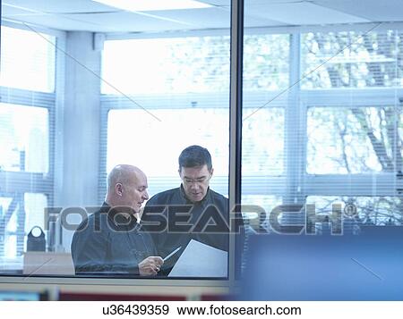 Two male engineer designers discussing plans in office View Large Photo Image Stock Photo - Two male engineer designers discussing plans in office. Fotosearch