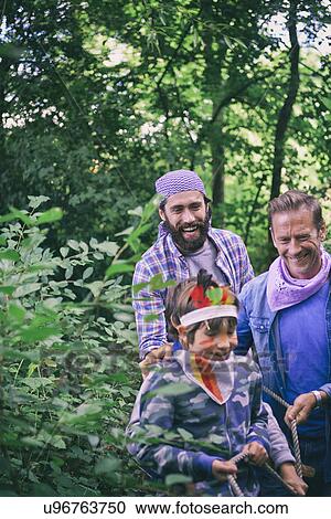 Two men captured with rope by boy in forest View Large Photo Image Stock Image - Two men captured with rope by boy in forest. Fotosearch