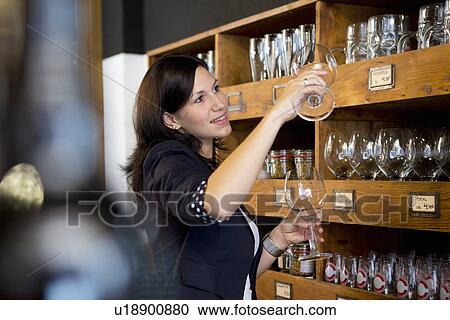 Woman checking wine glasses in shop View Large Photo Image Stock Image - Woman checking wine glasses in shop. Fotosearch