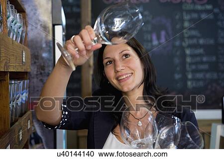 Woman checking wine glasses in shop View Large Photo Image Stock Image - Woman checking wine glasses in shop. Fotosearch