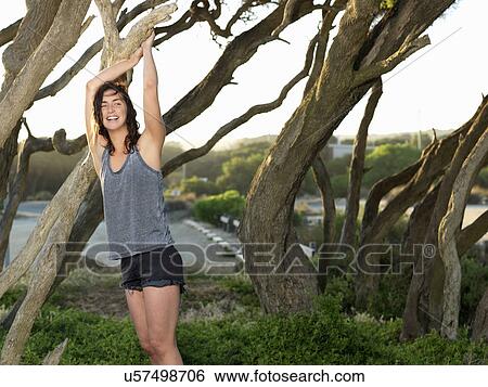 Stock Photograph - "Woman relaxing by trees, Roadknight, Victoria, Australia". Fotosearch