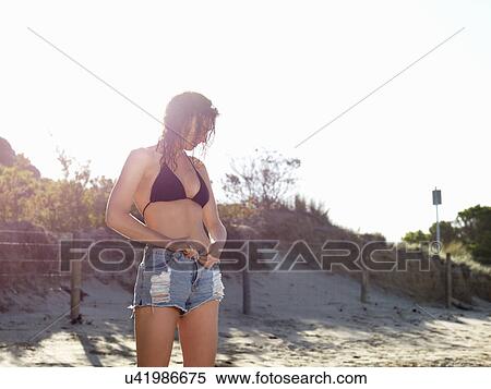 "Woman removing shorts on beach, Roadknight, Victoria, Australia" View Large Photo Image Stock Photography - "Woman removing shorts on beach, Roadknight, Victoria, Australia". Fotosearch