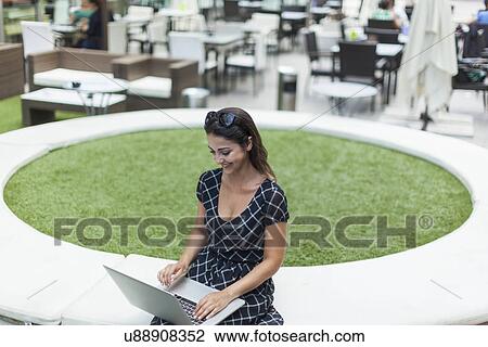 Woman using laptop by outdoor cafe View Large Photo Image Stock Image - Woman using laptop by outdoor cafe. Fotosearch