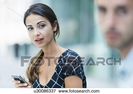 "Woman using phone, colleague beside her" View Large Photo Image Stock Photo - "Woman using phone, colleague beside her". Fotosearch