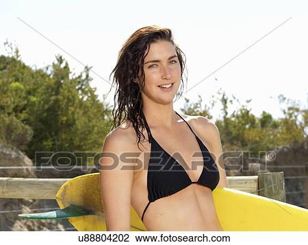 Stock Image - "Woman with surfboard, Roadknight, Victoria, Australia". Fotosearch