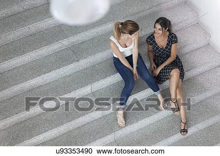 Women sitting on stairs having discussion View Large Photo Image Stock Image - Women sitting on stairs having discussion. Fotosearch