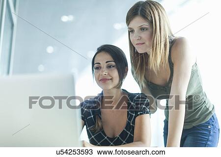 Women using laptop in the library View Large Photo Image Stock Image - Women using laptop in the library. Fotosearch