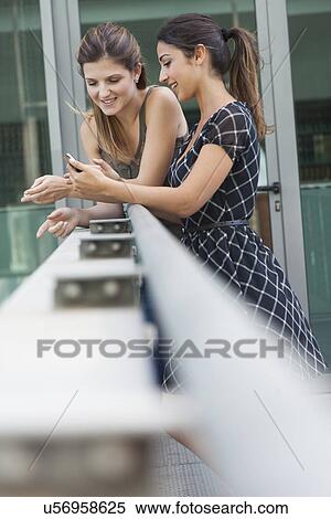 Women using phone outside the library View Large Photo Image Stock Photography - Women using phone outside the library. Fotosearch