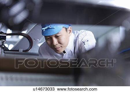 Worker using machinery in factory that specialises in creating functional circuits on flexible surfaces View Large Photo Image Stock Image - Worker using machinery in factory that specialises in creating functional circuits on flexible surfaces. Fotosearch