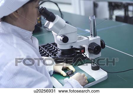 Worker using microscope in factory that specialises in creating functional circuits on flexible surfaces View Large Photo Image Stock Image - Worker using microscope in factory that specialises in creating functional circuits on flexible surfaces. Fotosearch