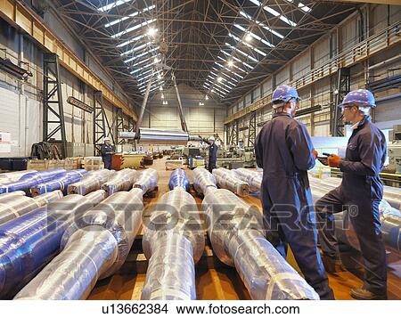 Picture - Workers in discussion in large engineering factory. Fotosearch