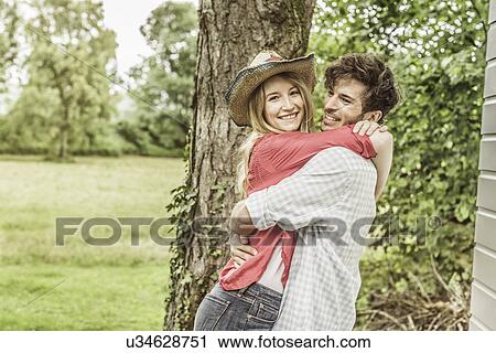 Young couple hugging in garden View Large Photo Image Stock Image - Young couple hugging in garden. Fotosearch