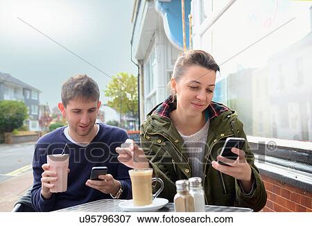 Young couple using smartphones View Large Photo Image Stock Photo - Young couple using smartphones. Fotosearch