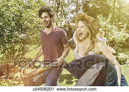 Young couple walking in garden preparing for picnic View Large Photo Image Stock Image - Young couple walking in garden preparing for picnic. Fotosearch