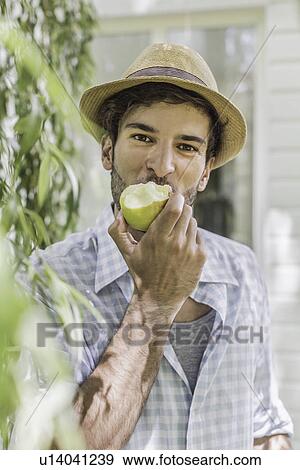 Young man eating apple View Large Photo Image Stock Photo - Young man eating apple. Fotosearch