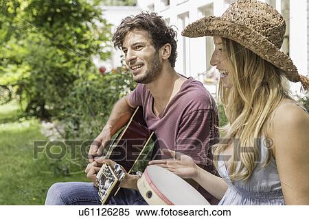"Young man playing guitar, woman with tambourine" View Large Photo Image Stock Photography - "Young man playing guitar, woman with tambourine". Fotosearch