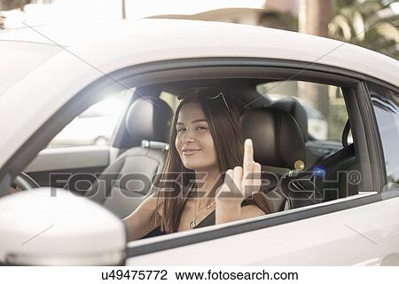 "Young woman driving car, making obscene gesture with finger" View Large Photo Image Stock Image - "Young woman driving car, making obscene gesture with finger". Fotosearch