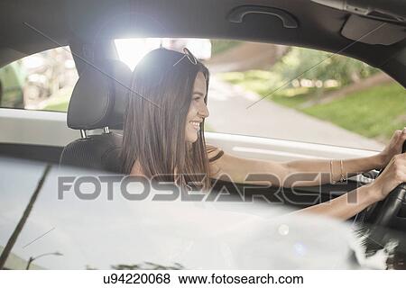 Stock Photo - Young woman driving car. Fotosearch