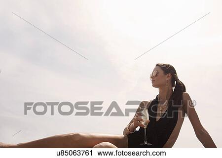 "Young woman in swimsuit with champagne, portrait" View Large Photo Image Stock Image - "Young woman in swimsuit with champagne, portrait". Fotosearch