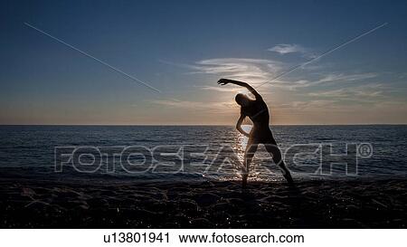 "Young woman practicing yoga at sunset, Oristano, Sardinia, Italy" View Large Photo Image Stock Image - "Young woman practicing yoga at sunset, Oristano, Sardinia, Italy". Fotosearch