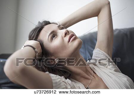 Young woman reclining with hands in hair View Large Photo Image Stock Image - Young woman reclining with hands in hair. Fotosearch