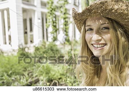 "Young woman wearing straw hat, portrait" View Large Photo Image Stock Image - "Young woman wearing straw hat, portrait". Fotosearch