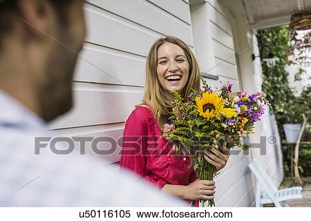 Young woman with bunch of flowers in front porch View Large Photo Image Stock Photography - Young woman with bunch of flowers in front porch. Fotosearch