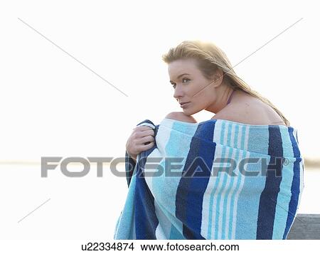 "Young woman wrapped in beach towel and hugging knees, Altona, Melbourne, Victoria, Australia" View Large Photo Image Picture - "Young woman wrapped in beach towel and hugging knees, Altona, Melbourne, Victoria, Australia". Fotosearch